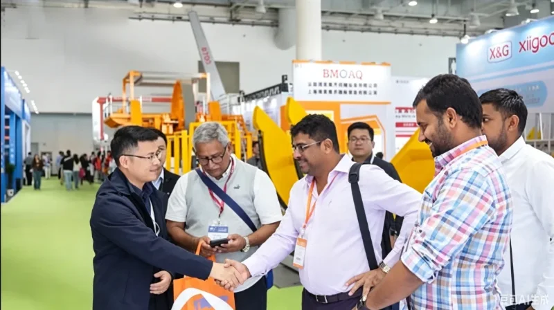 Business handshake between APEX team and overseas buyers at 26th Xiamen International Stone Fair 2026 for AI mineral sorting equipment