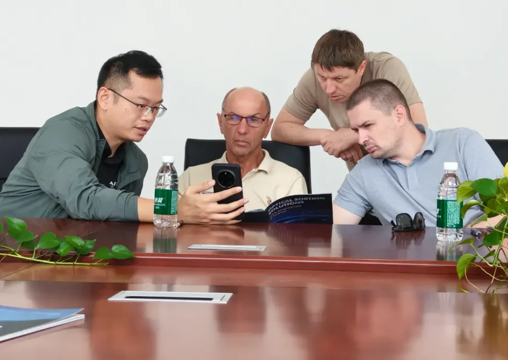 Business negotiation meeting between Russian vegetable‑processing client and APEX technical‑sales team in conference room