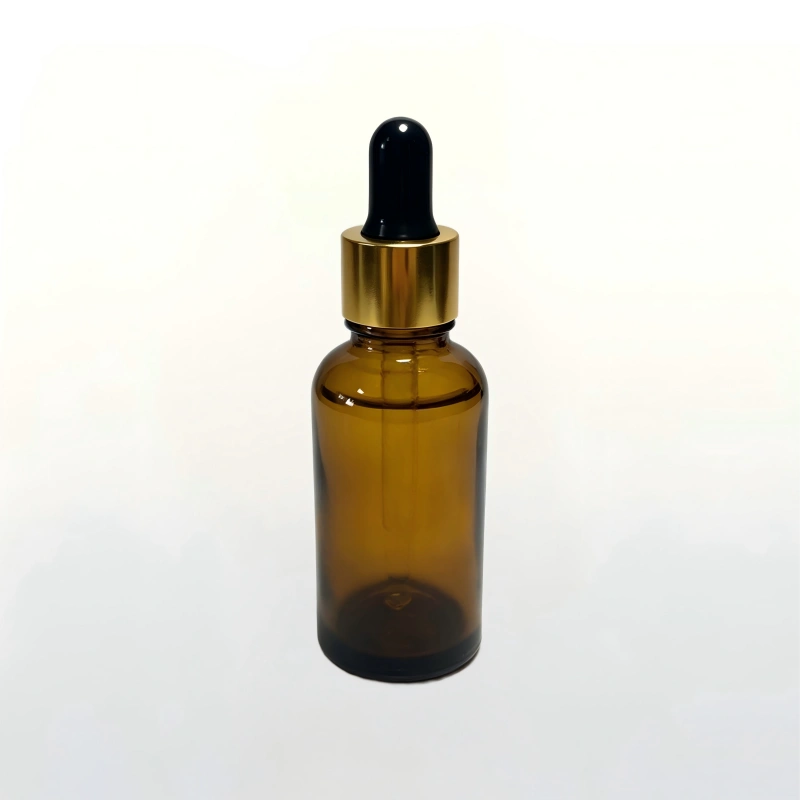 Premium shiny gold dropper cap with black rubber bulb and glass pipette for cosmetic serum packaging