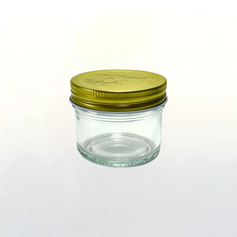 Main product shot 100ml clear short round glass caviar jar with gold printed metal screw lid