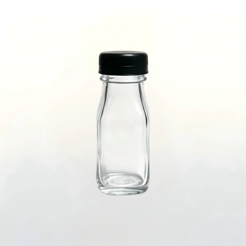 Square clear glass dairy beverage bottle fitted with black plastic screw cap