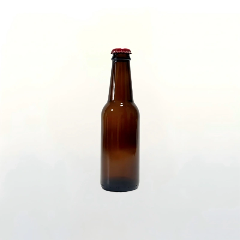 Botella de vidrio estándar de cerveza artesanal ámbar de 250 ml con fondo blanco puro y tapón de corona rojo.