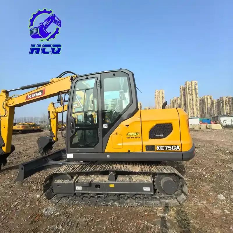 Mini escavadeira XCMG XE75GA usada com lâmina de bulldozer em um pátio de cascalho.