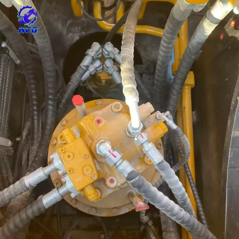 Visão aproximada do motor hidráulico de giro de uma escavadeira e das mangueiras conectadas, mostrando os principais componentes a serem inspecionados durante a verificação do sistema hidráulico de uma escavadeira usada, buscando vazamentos, conexões e desgaste.