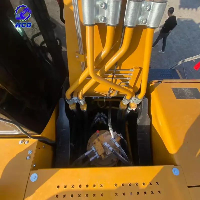 Vista superior do coletor hidráulico e conjunto da válvula de prioridade de uma escavadeira com tubos amarelos, demonstrando uma seção crítica para verificar vazamentos, conexões soltas e roteamento adequado durante a inspeção do sistema hidráulico de uma escavadeira usada.