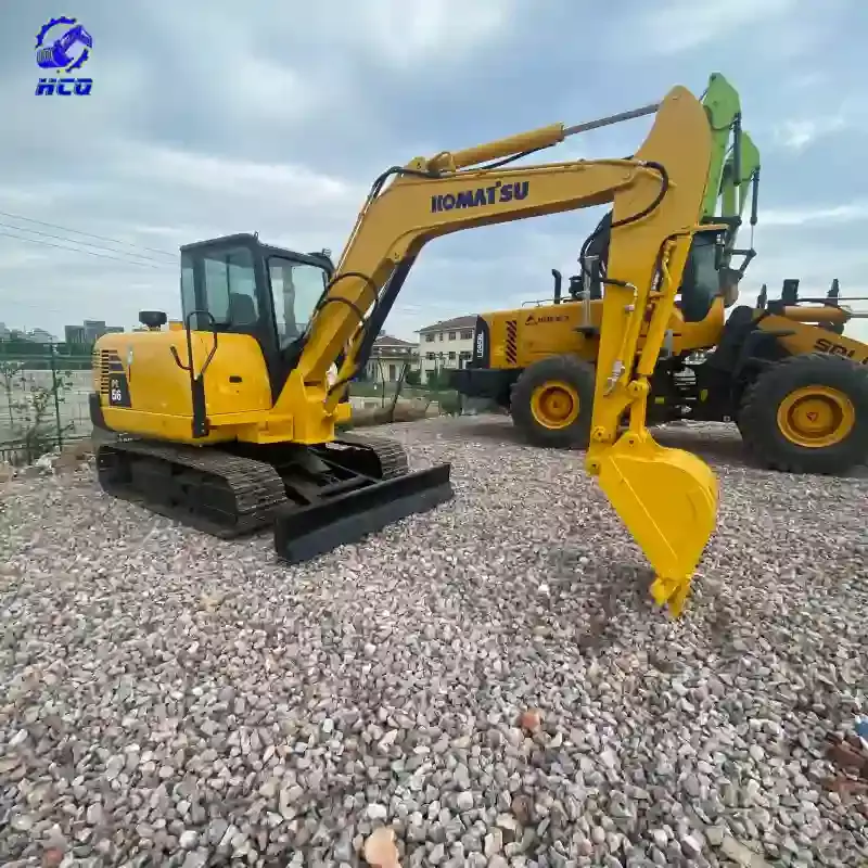 Comment savoir si une pelle d'occasion a été repeinte ? – Vue de profil d'une mini-pelle Komatsu PC56 jaune montrant la peinture du bras et du châssis.