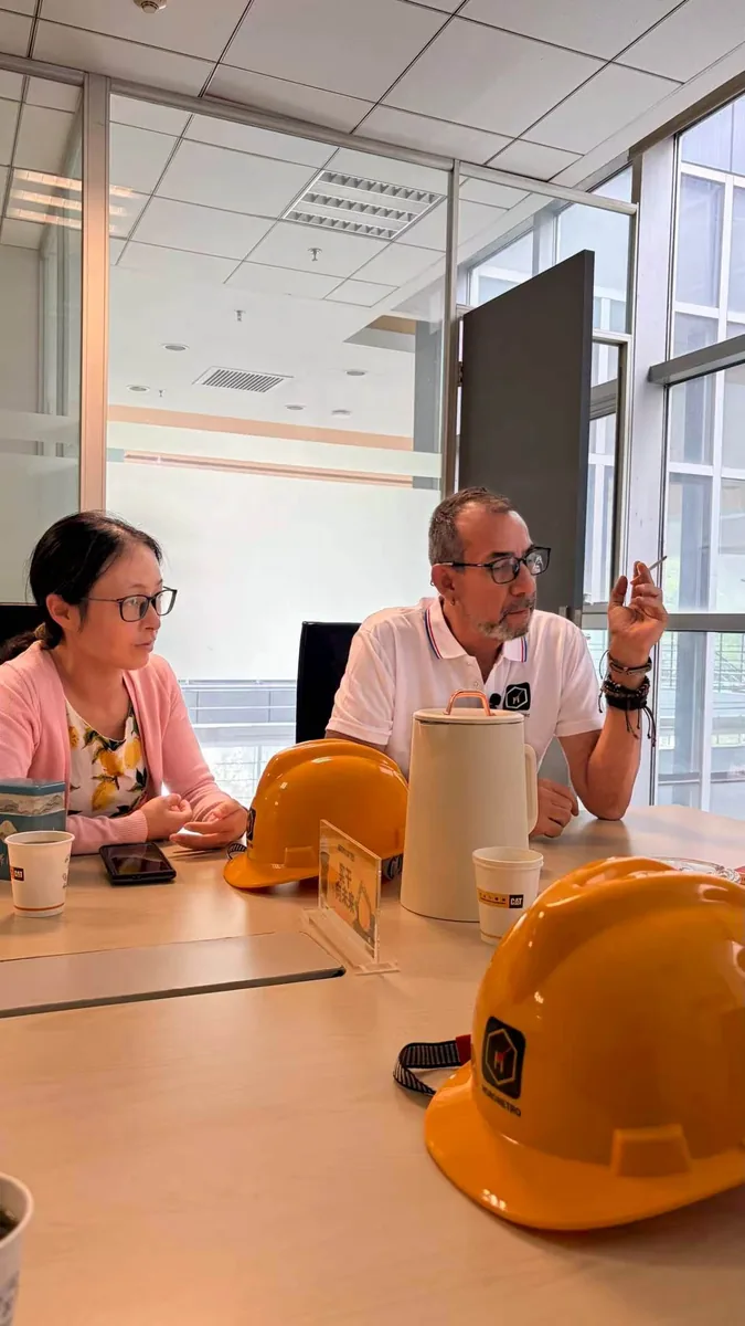 Un acheteur colombien discute avec un membre du personnel d'HCQ à la table de réunion du bureau de Hefei