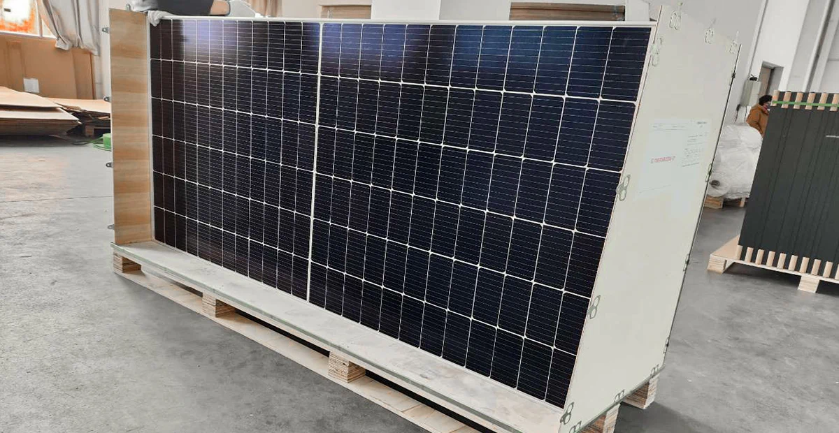 Solar panel pallet unpacked interior, removed outer packaging revealing protective corners, edge guards, and module surface