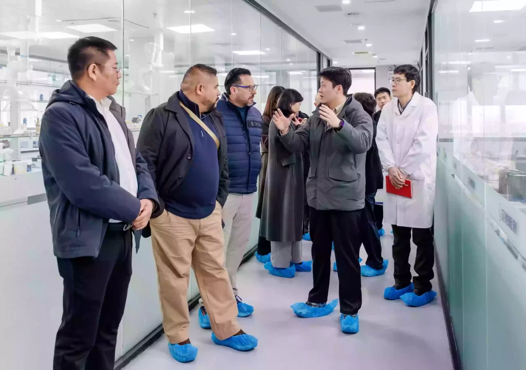 Zhongtian technicians demonstrating CNG diesel engine oil high-temperature oxidation resistance testing to Mexican clients in the R&D laboratory.